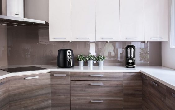 A wood finish kitchen with a Devanti air fryer and vacuum blender.