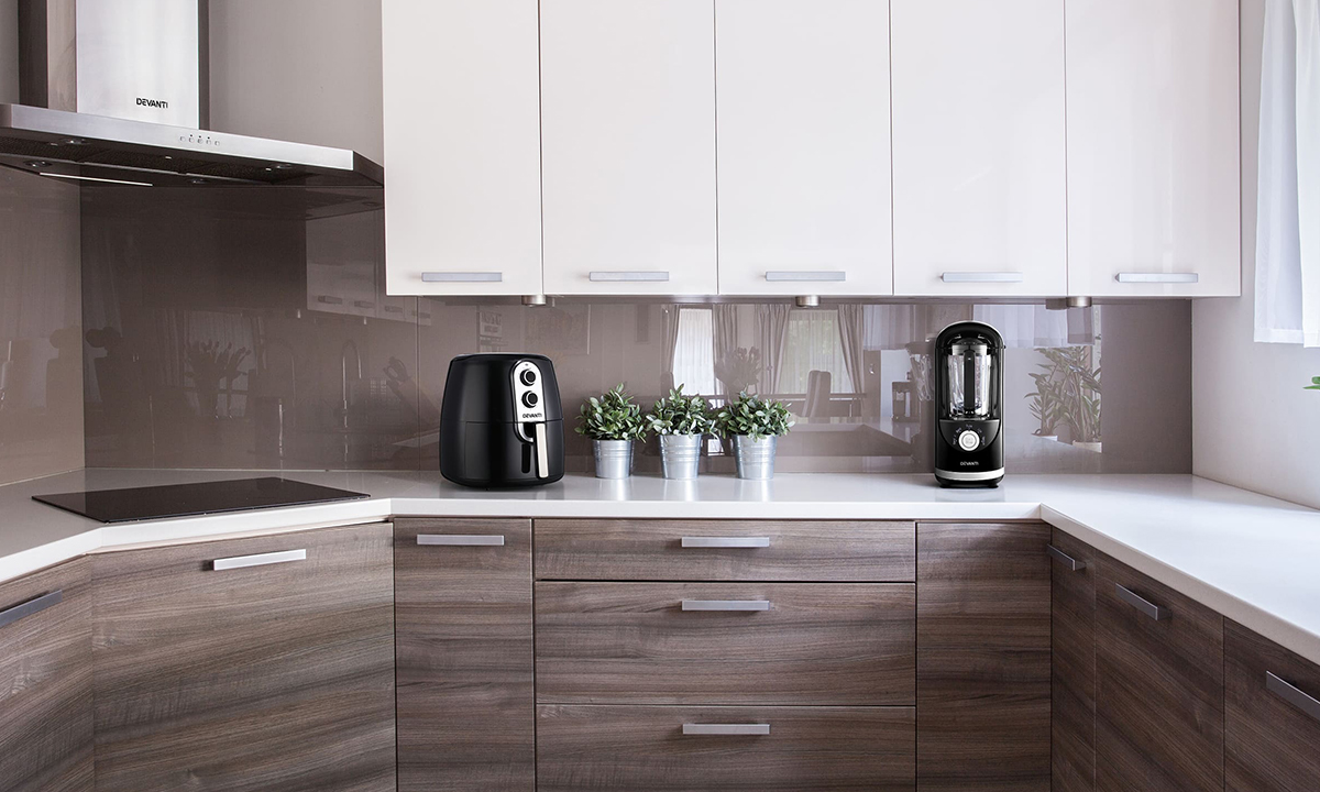 A wood finish kitchen with a Devanti air fryer and vacuum blender.